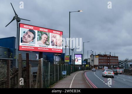 Propeller Park, 400 North Circular Road, 27. Dezember 2023. Eine rotierende digitale Plakatkampagne des "Geiseln- und Vermisstenfamilien Forum UK", in der Fotos von einigen der entführten israelischen Zivilisten gezeigt werden, die am 7. Oktober 2023 von der Hamas aufgenommen wurden. Die Kampagne zielt darauf ab, die Not der Männer, Frauen und Kinder, die noch immer als Geiseln im Gazastreifen gehalten werden, in die Öffentlichkeit zu rücken. Foto: Amanda Rose/Alamy Live News Stockfoto