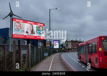 Propeller Park, 400 North Circular Road, 27. Dezember 2023. Eine rotierende digitale Plakatkampagne des "Geiseln- und Vermisstenfamilien Forum UK", in der Fotos von einigen der entführten israelischen Zivilisten gezeigt werden, die am 7. Oktober 2023 von der Hamas aufgenommen wurden. Die Kampagne zielt darauf ab, die Not der Männer, Frauen und Kinder, die noch immer als Geiseln im Gazastreifen gehalten werden, in die Öffentlichkeit zu rücken. Foto: Amanda Rose/Alamy Live News Stockfoto