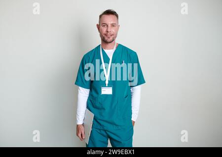 Porträt eines lächelnden, Reifen Physiotherapeuten mit Klemmbrett an weißer Wand Stockfoto