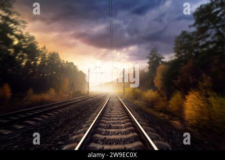 Eisenbahn im Herbstwald. Eisenbahngleise durch den Wald. Bewegungsunschärfeeffekt. Stockfoto