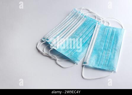 Set von chirurgischen Masken mit Gummi-Ohrbügeln zum Schutz vor Influenza und Viren auf weißem Hintergrund. Stockfoto