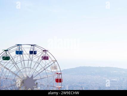 Riesenrad mit mehrfarbigen Fahrerhäusern auf blauem Himmel Stockfoto