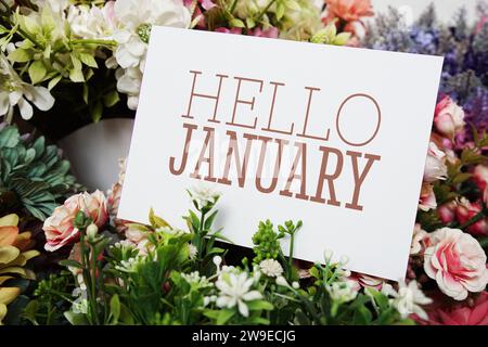 Hallo Januar Textnachricht auf Papierkarte mit wunderschöner Blumendekoration Stockfoto