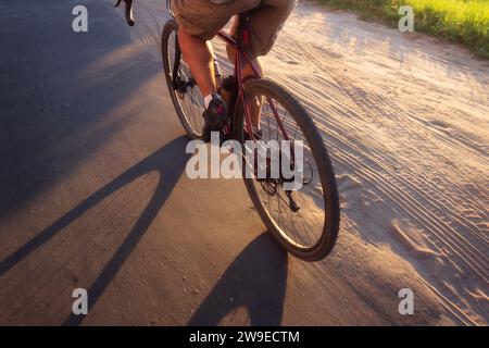 Radfahrer fahren bei Sonnenuntergang auf der Straße. Ansicht von oben Active Lifestyle Konzept. Stockfoto