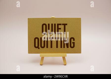 Leise beendende Textnachricht mit Holzstaffelei auf rosa Hintergrund Stockfoto