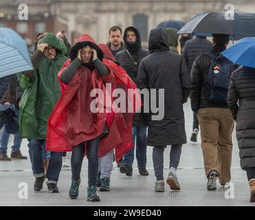 Menschen trotzen dem Wetter, wenn sie die Millennium Bridge in London überqueren. Sturm Gerrit wird am Mittwoch starke Winde und starke Regenfälle in viele Teile Großbritanniens bringen, wobei auch winterliche Gefahren wahrscheinlich sind, warnten die Wettervorhersagen. Bilddatum: Mittwoch, 27. Dezember 2023. Stockfoto