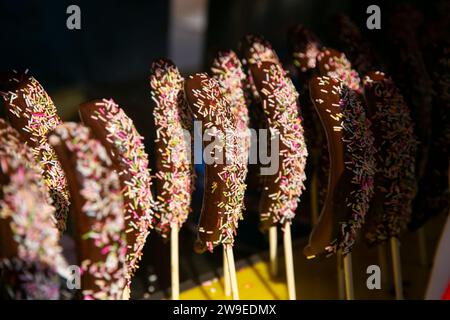 Bananen in Schokolade getaucht mit farbigen Bonbons. Stockfoto