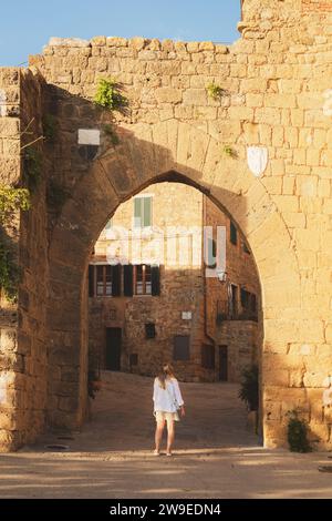 Eine junge blonde Touristenin erkundet die Hintergassen des malerischen und charmanten toskanischen Dorfes Monticchiello in der Toskana, Italien. Stockfoto