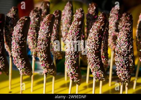 Bananen in Schokolade getaucht mit farbigen Bonbons. Stockfoto