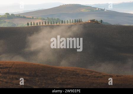 Morgennebel durch das Tal von Val d'Orcia in der malerischen Landschaft Ackerland und sanften Hügeln der ländlichen Toskana, Italien. Stockfoto
