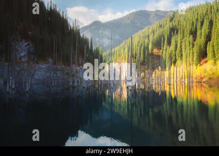 Farbenfrohe Berglandschaft des Kaindy Lake mit untergetauchten Baumstämmen im Nationalpark Kolsai Lakes in Saty, Kasachstan. Stockfoto