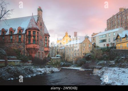 Malerisches und historisches Dean Village, bedeckt mit Schnee am Wasser von Leith während eines Winteruntergangs in Edinburgh, Schottland. Stockfoto