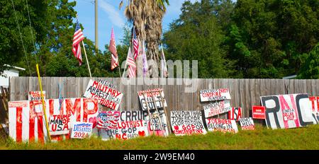 OCALA, FLORIDA, USA - 22. OKTOBER 2023 Pro-Präsident Trumpf unterzeichnet Anti-Biden, republikanisch gegen demokratische politische Partei, die mit der amerikanischen fla auf Zäune steht Stockfoto