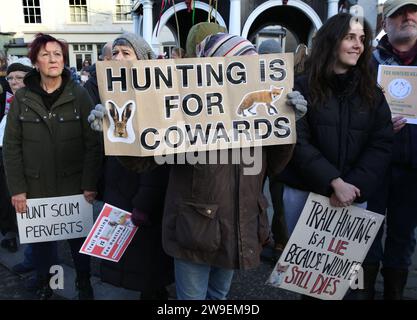 Bungay, Großbritannien. Dezember 2023. Die Demonstranten halten Plakate, auf denen die Jagd und die Anhänger der Jagd während der Demonstration kritisiert werden. Im Stadtzentrum von Bungay wurde Protest gegen Tierquälerei abgehalten, als die Waveney und Norfolk Harriers durch die Straßen ziehen und die Landsleute unterstützen. Die Demonstranten sagten, dass trotz ihres Verbots der traditionellen Fuchsjagd Tiere immer noch während der Wanderjagd getötet werden und sie fordern ein totales Verbot. (Foto von Martin Pope/SOPA Images/SIPA USA) Credit: SIPA USA/Alamy Live News Stockfoto