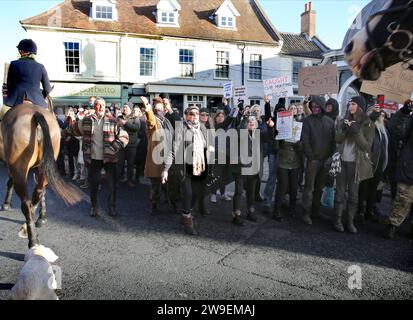 Bungay, Großbritannien. Dezember 2023. Jagd-Demonstranten schwenken Plakate, während die Reiter und Hunde während der Jagdparade am zweiten Weihnachtsfeiertag vorbeifahren. Im Stadtzentrum von Bungay wurde Protest gegen Tierquälerei abgehalten, als die Waveney und Norfolk Harriers durch die Straßen ziehen und die Landsleute unterstützen. Die Demonstranten sagten, dass trotz ihres Verbots der traditionellen Fuchsjagd Tiere immer noch während der Wanderjagd getötet werden und sie fordern ein totales Verbot. (Foto von Martin Pope/SOPA Images/SIPA USA) Credit: SIPA USA/Alamy Live News Stockfoto