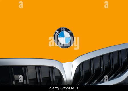 OCALA, FLORIDA - 2. NOVEMBER 2023 BMW-Logo-Emblem in leuchtend orangefarbener Fahrzeugfront. Bavaria Motor Works ist ein deutscher multinationaler Hersteller von Luxusfahrzeugen Stockfoto