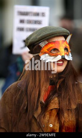 Bungay, Suffolk, Großbritannien. Dezember 2023. Eine Demonstrantin trägt eine Fuchs-Gesichtsmaske, während sie sich dem Protest anschließt. Im Stadtzentrum von Bungay wurde Protest gegen Tierquälerei abgehalten, als die Waveney und Norfolk Harriers durch die Straßen ziehen und die Landsleute unterstützen. Die Demonstranten sagten, dass trotz ihres Verbots der traditionellen Fuchsjagd Tiere immer noch während der Wanderjagd getötet werden und sie fordern ein totales Verbot. (Credit Image: © Martin Pope/SOPA Images via ZUMA Press Wire) NUR REDAKTIONELLE VERWENDUNG! Nicht für kommerzielle ZWECKE! Stockfoto