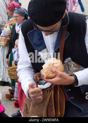 Parade von Kostümen und traditionellen Masken Iberiens vor dem Königspalast. Maragato-Kostüm und Tanz mit Kastanien. Stockfoto