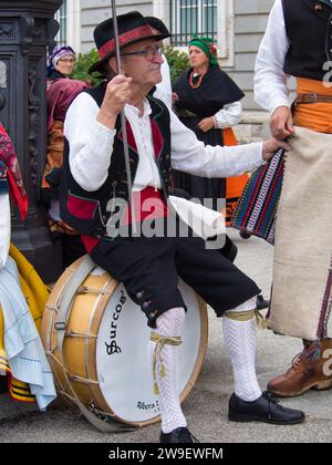 Parade von Kostümen und traditionellen Masken Iberiens vor dem Königspalast. Maragato-Kostüm und Tanz mit Kastanien. Stockfoto