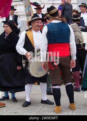 Parade von Kostümen und traditionellen Masken Iberiens vor dem Königspalast. Maragato-Kostüm und Tanz mit Kastanien. Stockfoto