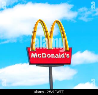 OCALA, FLORIDA USA - 14. OKTOBER 2023 McDonalds Logo blauer Himmel Hintergrund mit weißen Wolken. Gelbes, goldenes Schild mit dem Bogen, das von der belebten Straße aus gesehen hoch ist Stockfoto