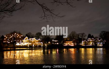 Ein See voller Weihnachtslichter, die nachts ein paar Tage vor Weihnachten im Babylon Village New York auf dem Wasser reflektieren. Stockfoto