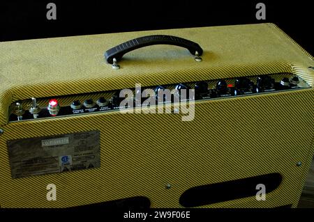 Altes Vintage Retro Stil Gitarrenröhre Verstärker oder Verstärker gelb Tweed Design isoliert auf dunklem Hintergrund. Steuern Sie Lautstärke, Höhen, Bässe, Tontasten und Stockfoto