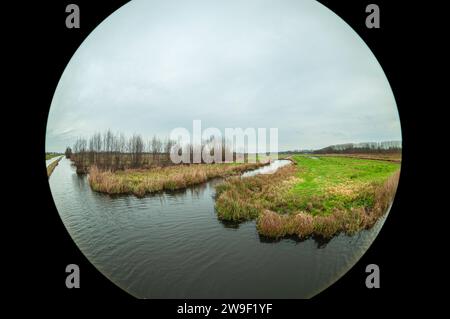 Extremer Weitwinkelblick der wässrigen niederländischen Polderlandschaft bei Gouda im westlichen Teil der Niederlande. Stockfoto