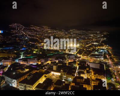 Ein Baum mit Silhouette steht auf einem Gebäude, während ein Stern am Nachthimmel funkelt: Madeira, Funchal an Weihnachten in der Nacht Stockfoto