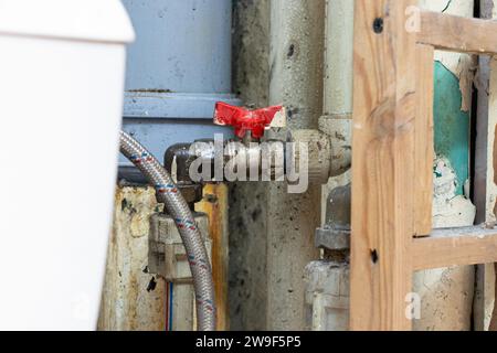 Alte schmutzige Rohre und Plastikrohre und Wasserhahn im Badezimmer einer Wohnwohnung ohne Reparatur, Austausch der Rohre, Klempner Stockfoto