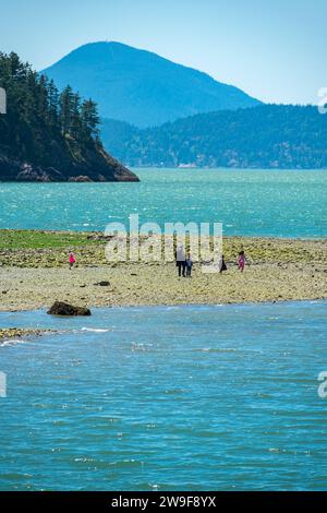 Familien genießen einen Tag in Porteau Cove mit seinen Kiesstränden und majestätischen Bergblicken im Hintergrund. Stockfoto