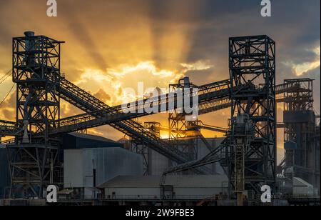 Dramatischer Sonnenuntergang über den Maschinen der Laderampe in Port Allen am Mississippi River in Baton Rouge, Louisiana Stockfoto