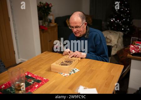 Großeltern spielen Tischplatten-Flipperspiel am Weihnachtstag, England, Großbritannien Stockfoto