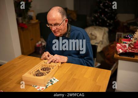 Großeltern spielen Tischplatten-Flipperspiel am Weihnachtstag, England, Großbritannien Stockfoto