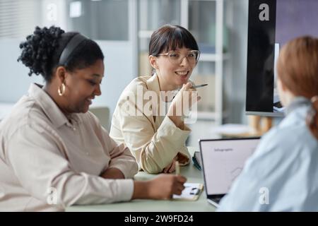 Fröhliche Geschäftsfrau, die mit Kollegen spricht Stockfoto
