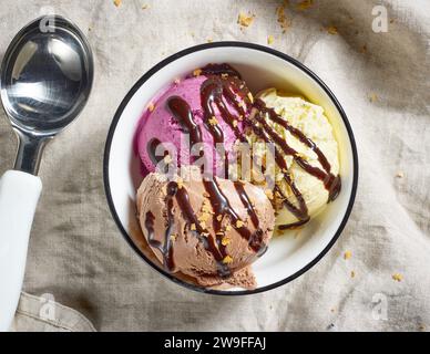 Schüssel mit verschiedenen Eissorten dekoriert mit Schokoladensoße, Blick von oben Stockfoto