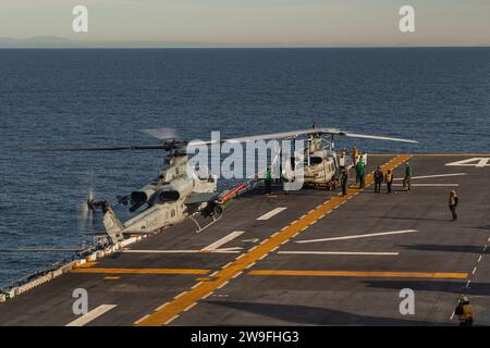 Ein U.S. Marine Corps AH-1Z Viper, das der Marine Medium Tiltrotor Squadron (VMM) 165 (verstärkt), 15. Marine Expeditionary Unit, angegliedert ist, bereitet sich vor, am 10. Dezember 2023 auf dem Flugdeck des amphibischen Angriffsschiffs USS Boxer (LHD 4) im Pazifischen Ozean zu landen. Die 15. MEU ist derzeit an Bord der Boxer Amphibious Ready Group, die integrierte Trainings- und Routineoperationen in der 3. US-Flotte durchführt. (Foto des U.S. Marine Corps von CPL. Amelia Kang) Stockfoto