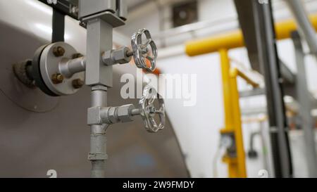 Als Kesselraum, Kessel und Anlagen. Wasserhahn für die Wasserversorgung in einem modernen Heizraum. Wärmeumwälzpumpen in Gewerbegebäuden, Industrie Stockfoto