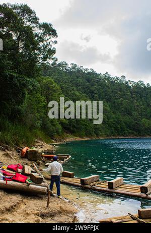 Ruhe am See: Vertikale Aufnahme des hölzernen Piers auf dem Chiapas See, azurblaue Gewässer, umgebender Wald, bedeckter Tag. Montebello's Lake. Stockfoto