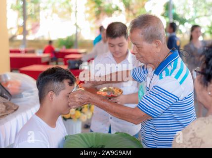 Bangkok, Thailand, 26. März 2021: Die Weihungen und Verwandte treffen sich, um den Kopf eines jungen Mannes zu rasieren, der kurz vor der Weihe steht, Accordin Stockfoto