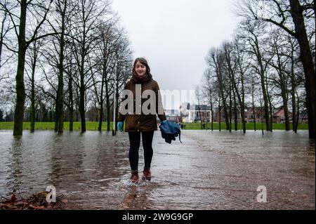 Deventer, Niederlande. Dezember 2023. Eine Frau wird in einem überfluteten Park gesehen. Aufgrund des steigenden Wassers in der IJssel stellt die Gemeinde Deventer Sandsäcke an den Kai, um die Altstadt zu schützen. Der starke Regen, der in den letzten Monaten gefallen ist, kombiniert mit der Tatsache, dass die Alpen für diese Jahreszeit ungewöhnlich warm sind, hat die IJssel in Overijssel, Gelderland, Drenthe, Brabant und Limburg überschwemmt. (Foto: Ana Fernandez/SOPA Images/SIPA USA) Credit: SIPA USA/Alamy Live News Stockfoto