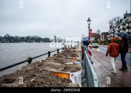 Deventer, Niederlande. Dezember 2023. Man sieht Menschen, die den mit Sandsäcken geschützten Kai entlang laufen. Aufgrund des steigenden Wassers in der IJssel stellt die Gemeinde Deventer Sandsäcke an den Kai, um die Altstadt zu schützen. Der starke Regen, der in den letzten Monaten gefallen ist, kombiniert mit der Tatsache, dass die Alpen für diese Jahreszeit ungewöhnlich warm sind, hat die IJssel in Overijssel, Gelderland, Drenthe, Brabant und Limburg überschwemmt. (Foto: Ana Fernandez/SOPA Images/SIPA USA) Credit: SIPA USA/Alamy Live News Stockfoto