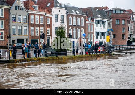 Deventer, Niederlande. Dezember 2023. Ein Blick vom Fluss von Menschen, die auf den Hochwasserspiegel schauen. Aufgrund des steigenden Wassers in der IJssel stellt die Gemeinde Deventer Sandsäcke an den Kai, um die Altstadt zu schützen. Der starke Regen, der in den letzten Monaten gefallen ist, kombiniert mit der Tatsache, dass die Alpen für diese Jahreszeit ungewöhnlich warm sind, hat die IJssel in Overijssel, Gelderland, Drenthe, Brabant und Limburg überschwemmt. Quelle: SOPA Images Limited/Alamy Live News Stockfoto