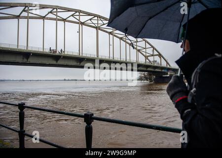 Deventer, Niederlande. Dezember 2023. Ein Mann sieht den Fluss IJssel bei Hochwasser. Aufgrund des steigenden Wassers in der IJssel stellt die Gemeinde Deventer Sandsäcke an den Kai, um die Altstadt zu schützen. Der starke Regen, der in den letzten Monaten gefallen ist, kombiniert mit der Tatsache, dass die Alpen für diese Jahreszeit ungewöhnlich warm sind, hat die IJssel in Overijssel, Gelderland, Drenthe, Brabant und Limburg überschwemmt. (Foto: Ana Fernandez/SOPA Images/SIPA USA) Credit: SIPA USA/Alamy Live News Stockfoto