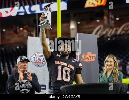 27. Dezember 2023: Der Oklahoma State Wide Receiver Rashod Owens (10) hält die wertvollste Spieler-Trophäe, als Head Coach Mike Gundy (links) nach dem Sieg der Cowboys über Texas A&M 31-23 im TaxAct Texas Bowl am 27. Dezember 2023 in Houston anblickt. (Kreditbild: © Scott Coleman/ZUMA Press Wire) NUR REDAKTIONELLE VERWENDUNG! Nicht für kommerzielle ZWECKE! Stockfoto