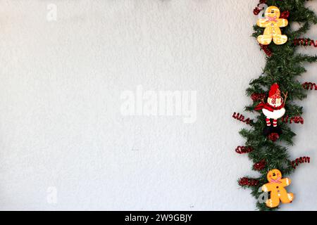 Weihnachtsmann, Schneemann und Lebkuchenkeks im weihnachtskranz mit grauem Hintergrund, weihnachtsdekoration Stockfoto