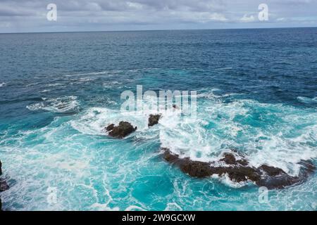 Panoramablick auf Los Hervideros aus der Vogelperspektive. Südwestküste, zerklüftete Vulkanküste, starke Brandung, Meereshöhlen, rote Lavahügel. Lanzarote, Kanarische Inseln, Spa Stockfoto