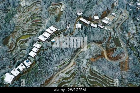 Peking, China. Dezember 2023. Dieses Luftbild, das am 19. Dezember 2023 aufgenommen wurde, zeigt einen Blick auf das Dorf Yaogao, Gandong Township im Autonomen County Rongshui Miao, südchinesische Autonomous Region Guangxi Zhuang. Ein Rendezvous mit Schnee erfrischt die Landschaft, während der Winter in den meisten Teilen Chinas seine Spuren verlässt. Quelle: Long Linzhi/Xinhua/Alamy Live News Stockfoto