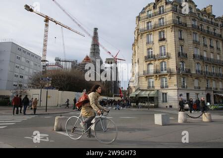 Paris, Frankreich. Dezember 2023. Ein Einheimischer fährt am 27. Dezember 2023 in Paris, Frankreich, am Bau der Kathedrale Notre-Dame vorbei. Die Arbeiter der Kathedrale Notre-Dame stützen das zerbrechliche Gebäude nach einem verheerenden Brand im 15. April 2019 weiter. (Foto von Paulo Amorim/SIPA USA) Credit: SIPA USA/Alamy Live News Stockfoto