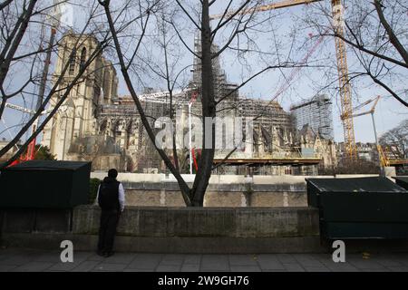 Paris, Frankreich. Dezember 2023. Eine Person sieht den Bau der Kathedrale Notre-Dame im Winter am 27. Dezember 2023 in Paris, Frankreich. Die Arbeiter der Kathedrale Notre-Dame stützen das zerbrechliche Gebäude nach einem verheerenden Brand im 15. April 2019 weiter. (Foto von Paulo Amorim/SIPA USA) Credit: SIPA USA/Alamy Live News Stockfoto